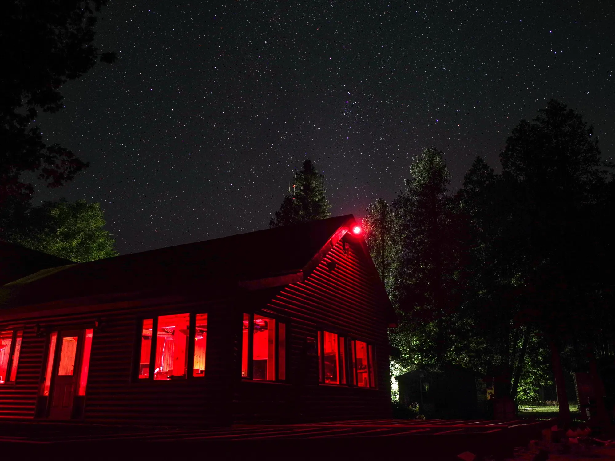Red Bay Lodge at night under a sky full of stars, its windows lit red